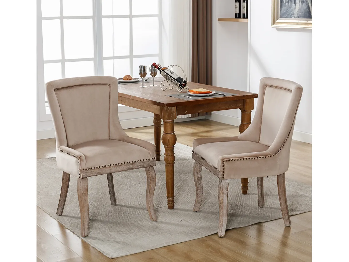 Conjunto de 2 sillas de terciopelo beige con patas de madera curvadas y remaches dorados.