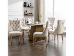 Conjunto de 6 sillas de terciopelo beige claro con patas de madera curvadas y botones decorativos.