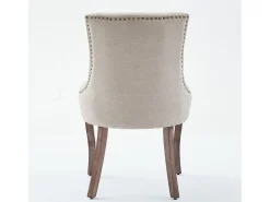 Juego de 2 sillas beige con patas de madera curvadas y ribete de tachuelas.
